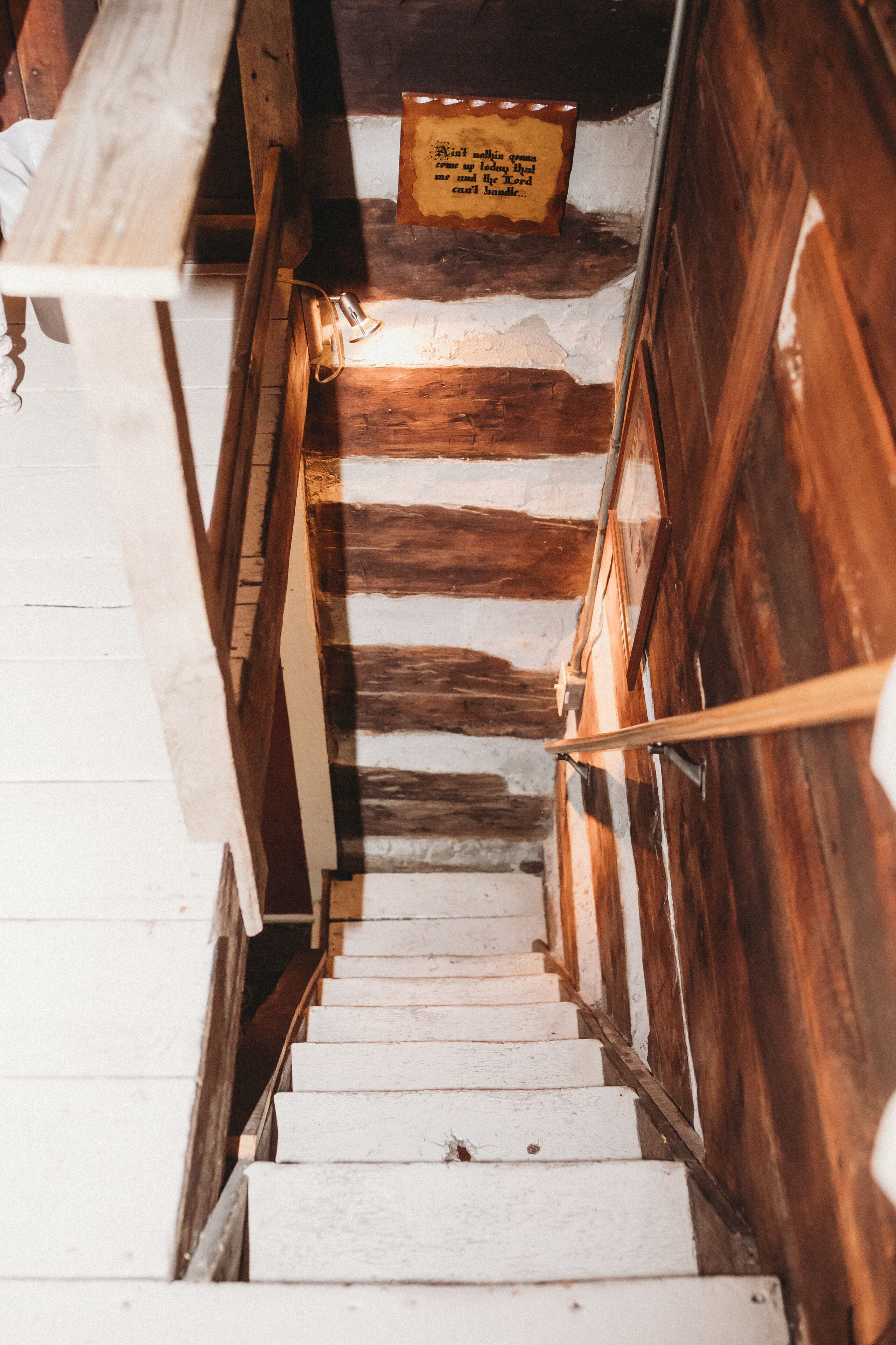 Una escalera de madera con escalones blancos y barandilla de madera.