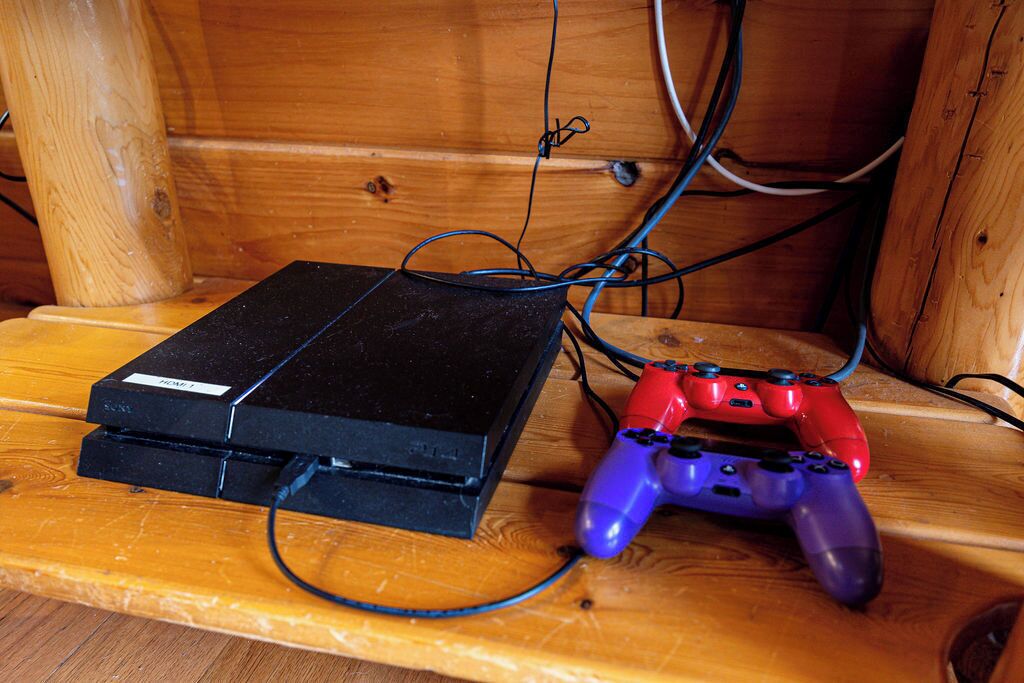 Un banc en bois avec une console PlayStation 2 et des manettes.