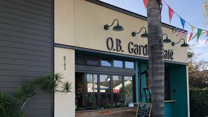 A building with a sign reading "O.B. Garden Cafe" and a "Happy Hour" sign.