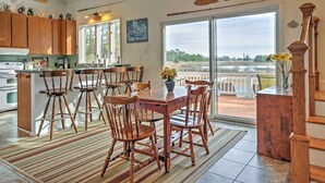 Een ruime keuken met houten kastjes, een eethoek met tafel en stoelen, en een grote schuifpui die uitkomt op een terras.