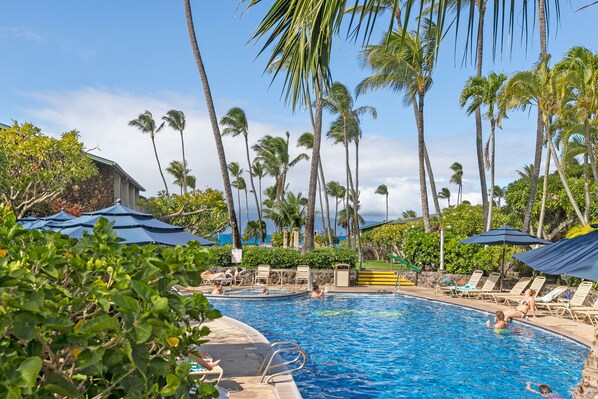 A swimming pool surrounded by palm trees and lounge chairs. - Beautiful 1BR Poolside Condo E141 w/AC, Sleeps 4, Near Napili Bay & Turtle Cove (Lahaina)