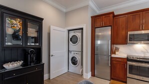 A compact kitchen with a built-in washer and dryer, wooden cabinets, and stainless steel appliances. - 4 Balconies, Water Views, Fireplace, Kitchen - Great For Groups (Newport)