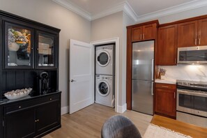 A compact kitchen with a built-in washer and dryer, wooden cabinets, and stainless steel appliances. - 4 Balconies, Water Views, Fireplace, Kitchen - Great For Groups (Newport)