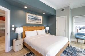 A bedroom with a large bed, two bedside tables with lamps, a painting on the wall, and a view of the outside through a window. - 4 Balconies, Water Views, Fireplace, Kitchen - Great For Groups (Newport)
