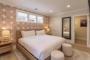 A bedroom with a bed, bedside tables, a mirror, and a window. - 4 Balconies, Water Views, Fireplace, Kitchen - Great For Groups (Newport)