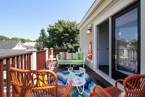 A covered outdoor patio with wicker chairs, a white table, and a green sofa. - 4 Balconies, Water Views, Fireplace, Kitchen - Great For Groups (Newport)