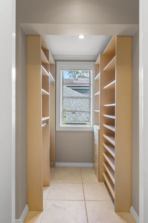 A narrow hallway with wooden shelving units on both sides and a window at the end. - Private Cable Beach villa with pool, oceanfront terrace & guest cottage (Cable Beach, Nassau)