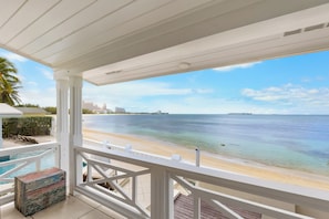 A balcony with a view of a beach and ocean. - Private Cable Beach villa with pool, oceanfront terrace & guest cottage (Cable Beach, Nassau)