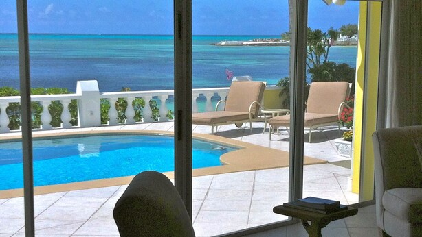A pool area with lounge chairs and a view of the ocean. - Luxury Beach--front house, perfect location! Cable Beach BEAUT! Walk to Baha Mar (Cable Beach, Nassau)