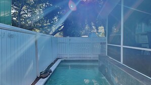 A small indoor pool with a wooden deck and a white fence. - Under The Tybee Sun | Pet Friendly, Private Pool (Tybee Island)