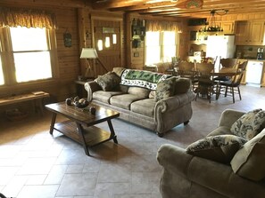 Relax in this inviting living room with a comfortable sofa, wooden coffee table, and dining area.