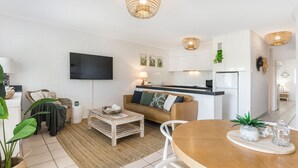 Un appartamento moderno con soggiorno, cucina e zona pranzo.