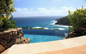 A stone pool with a view of the ocean and a rocky cliff. - Elegant Villa in Private Hope Bay. Infinity Pool with Sea View. (Bequia)