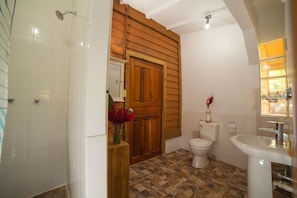 A bathroom with a shower, toilet, and sink. - PirateArts Experience (Bocas del Toro)