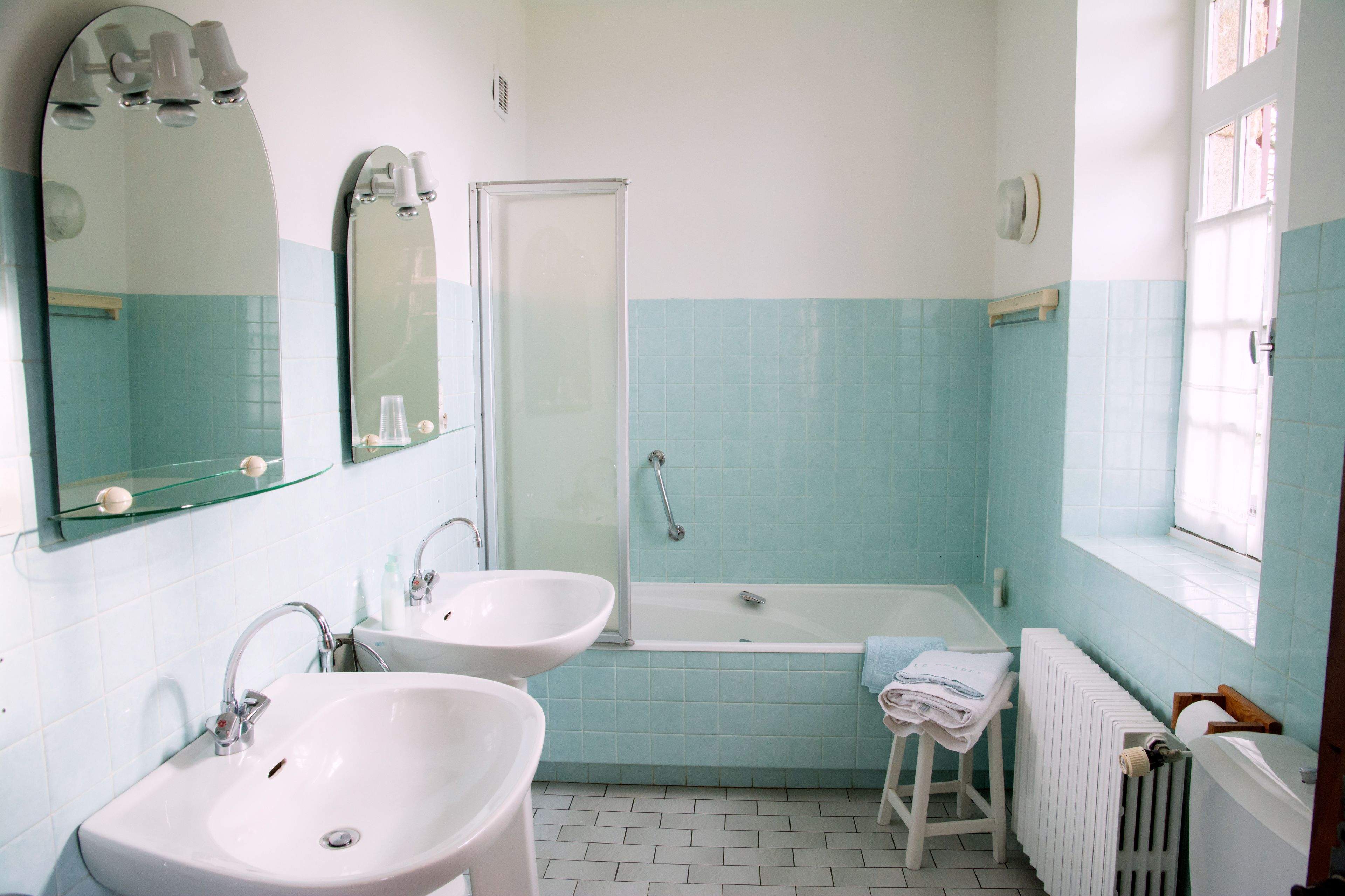 A bathroom with two sinks, a bathtub, and a shower.