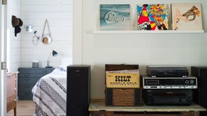 Una stanza con un letto, uno scaffale con diversi oggetti e un impianto audio.