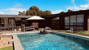 A swimming pool with a clear blue water surface, surrounded by a brick deck and a grassy area. - Devonlea Olive Grove
4br Home with pool on 8acres- next door to The Cups Estate (Fingal)