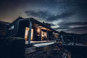 Une maison moderne dotée d’un porche abrité, d’un espace cuisine ouvert et d’une grande fenêtre.