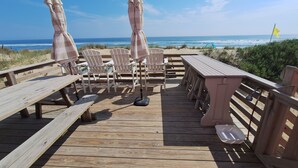 A wooden deck with picnic tables and chairs, overlooking the beach and ocean. - Right on the Beach and Dog Friendly! (Kitty Hawk)