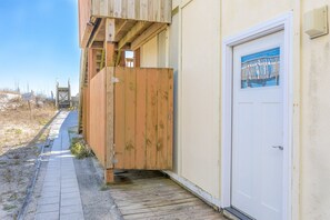 Een houten constructie met een deur en een raam, naast een verhard pad.