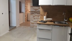 Une cuisine moderne avec des armoires blanches, un plan de travail en bois et un téléviseur encastré au-dessus du pare-feu.