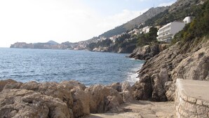 Une vue sur la côte, avec un paysage rocheux et un bâtiment doté de nombreux balcons donnant sur la mer.