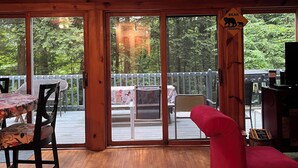 Un intérieur en bois avec de grandes fenêtres donnant sur une terrasse.