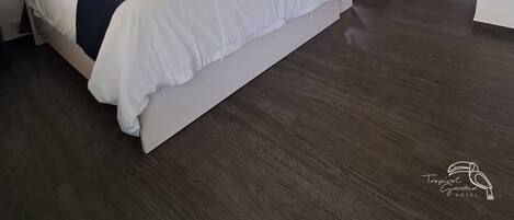 Un dormitori amb llit, sofà, petita cuina i finestra amb cortines.