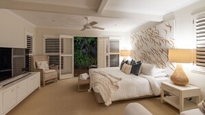 A bedroom with a bed, bedside table, lamp, TV, wardrobe, and a view of greenery through a door. - "Summer Salt" @ Sunshine + Pets & HEATED POOL 150m to the beach! (Noosa Heads)