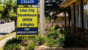 Motel Schild mit Check-in rund um die Uhr und Schild des Restaurants Golden Chain.