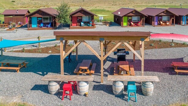 A campground with wooden cabins, picnic tables, and barbecue grills. - Cabin 4 · Emigrant Cabins #4- Tiny Cabin for your Adventure (Emigrant)