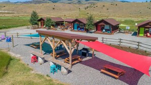 A campground with wooden cabins, picnic tables, and a barbecue area. - Cabin 4 · Emigrant Cabins #4- Tiny Cabin for your Adventure (Emigrant)