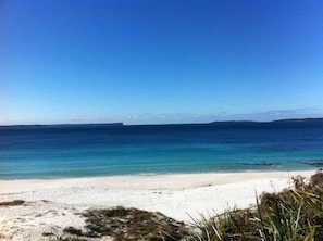 Ein Strand mit klarem, blauem Wasser und einem sandigen Ufer.