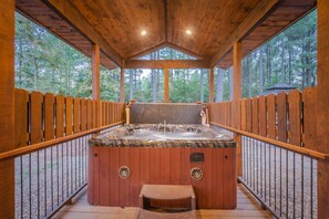 Relax in a hot tub surrounded by a forest view.