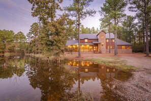 Escape to a serene woodland retreat with a lodge nestled beside a tranquil pond.