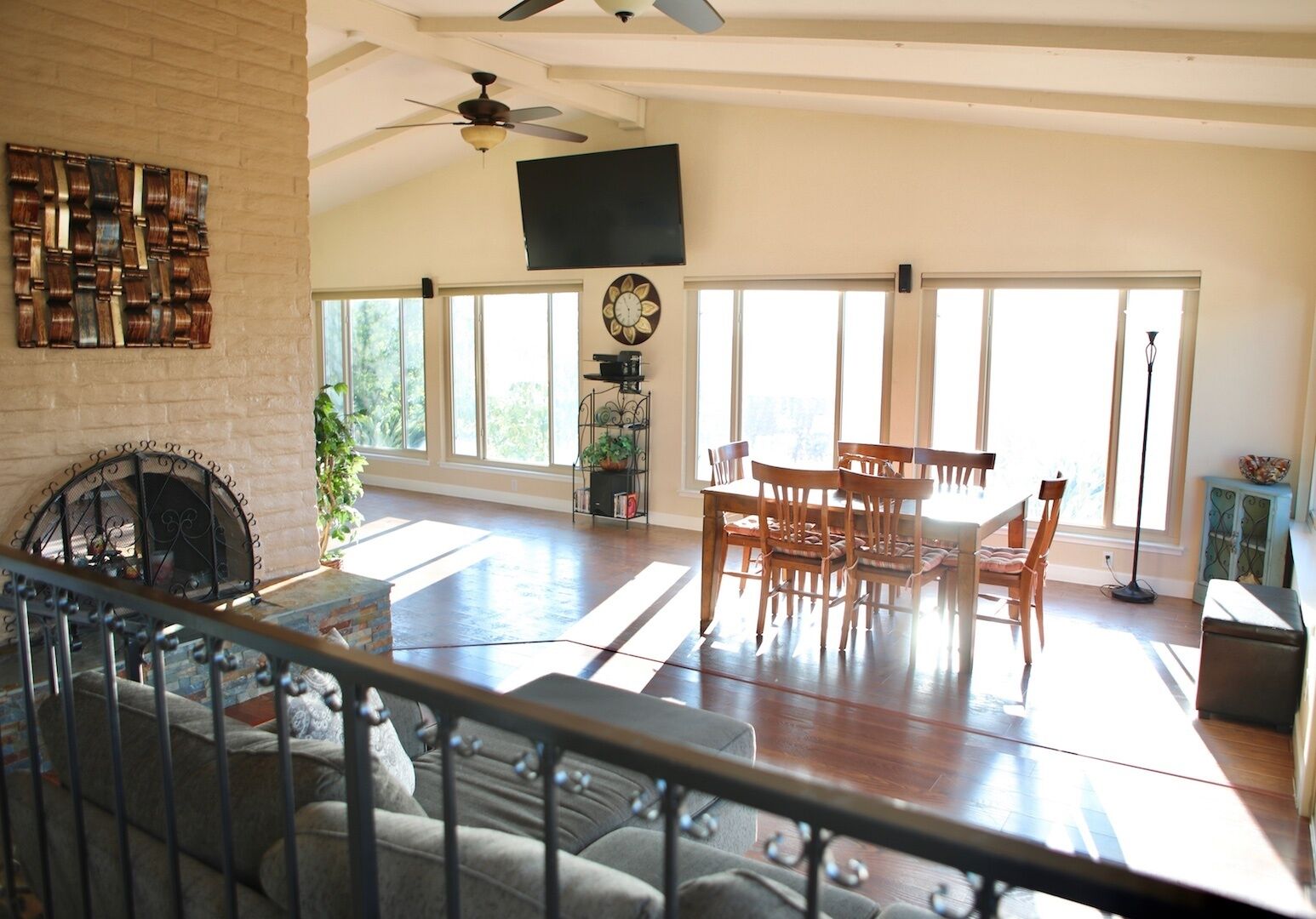 A spacious living room with a fireplace, a dining area, and large windows allowing natural light.