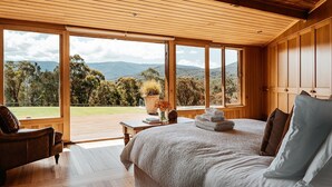 A bedroom with a large bed, wooden ceiling, and a view of the outdoors. - Luxurious Unique, Private Paradise-Kangaroo Manor (Yarra Valley)
