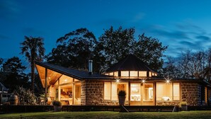 A stone house with a large glass window, a wooden deck, and a metal roof. - Luxurious Unique, Private Paradise-Kangaroo Manor (Yarra Valley)