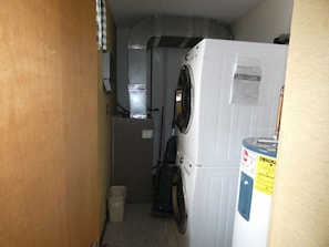 A laundry room with a washing machine, a dryer, and a trash bin.
