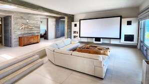Ein modernes Wohnzimmer mit einem Ecksofa, einem Flachbildfernseher und einer Wand mit Steinverkleidung.