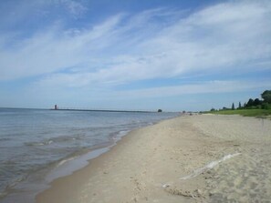 Enjoy a serene beach experience with a long pier offering scenic views.