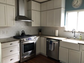 Kitchen features an oven, dishwasher, and stainless steel range hood.