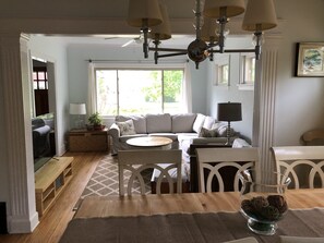 Relax and socialize in this inviting living area with a sofa, dining table, and large window.