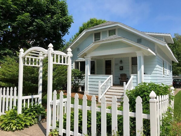 Stroll up the charming front porch to this inviting home, complete with a garden and white picket fence.