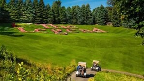 A golf course with a red-lettered 'The Lodge' sign in the center. - Playing Hookie at Schuss (mancelona)