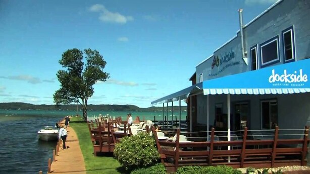A lakeside restaurant with outdoor seating and a view of the water. - Playing Hookie at Schuss (mancelona)
