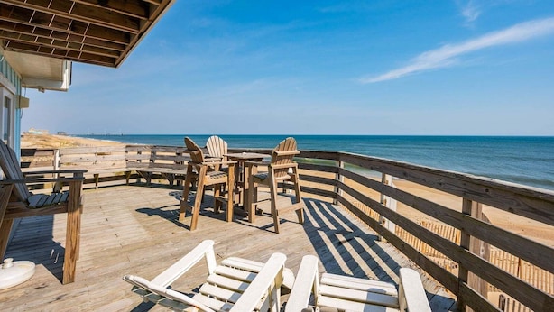 A wooden deck with chairs and tables overlooking the ocean. - 600 Nags Head Ocean-Front Completely Renovated (Nags Head)