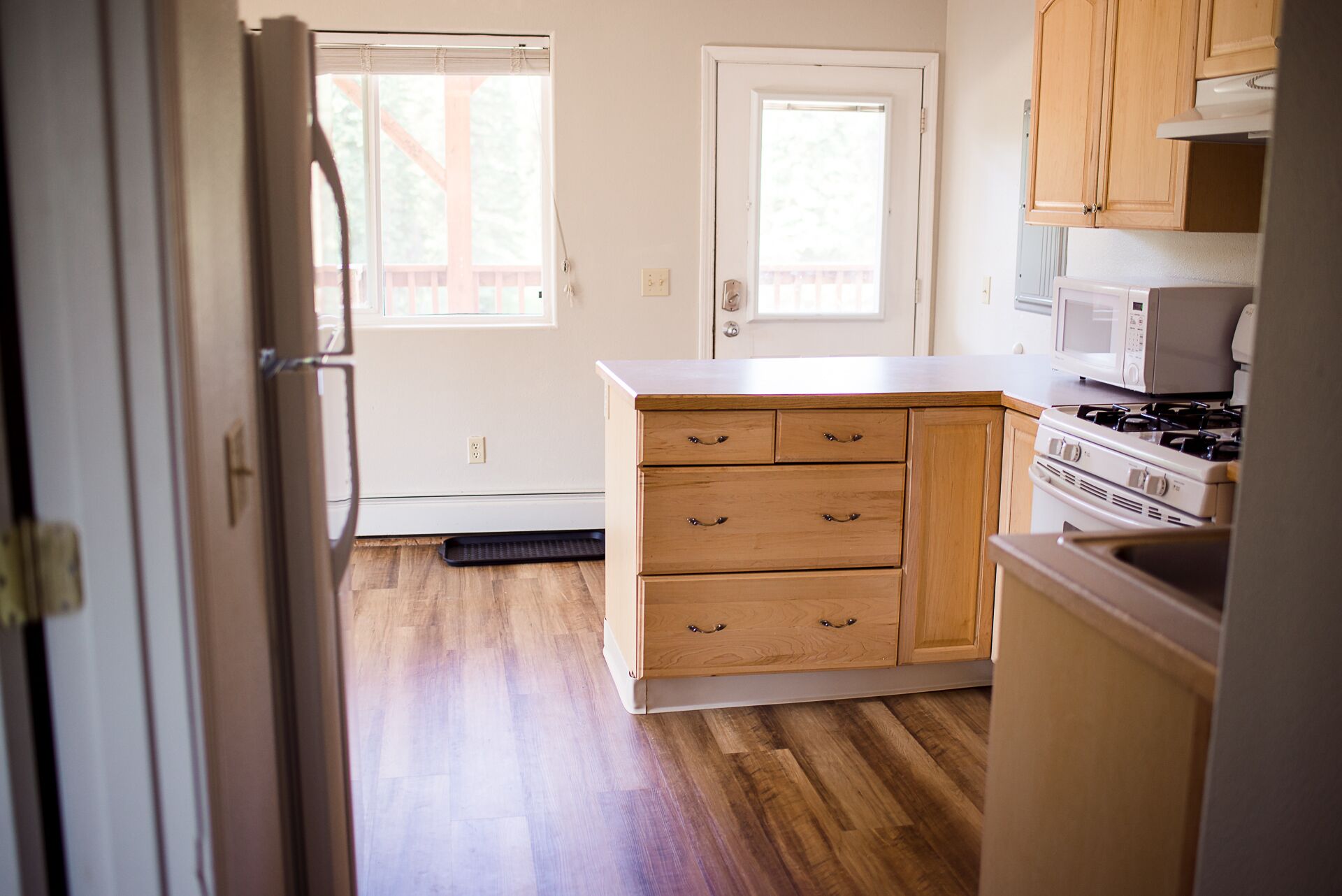 A kitchen with wooden cabinets, a stove, and a microwave.