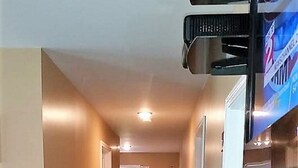 A narrow hallway with carpeted floors, white walls, and a door at the end. - Visiting Cooperstown NY or Oneonta NY areas stay at Abel's Acre's Hideaway House (Mt Vision)