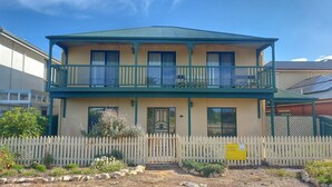 A two-story building with a balcony, a front door, and a picket fence. - Perfect Position in Port Elliot Wifi (Port Elliot)